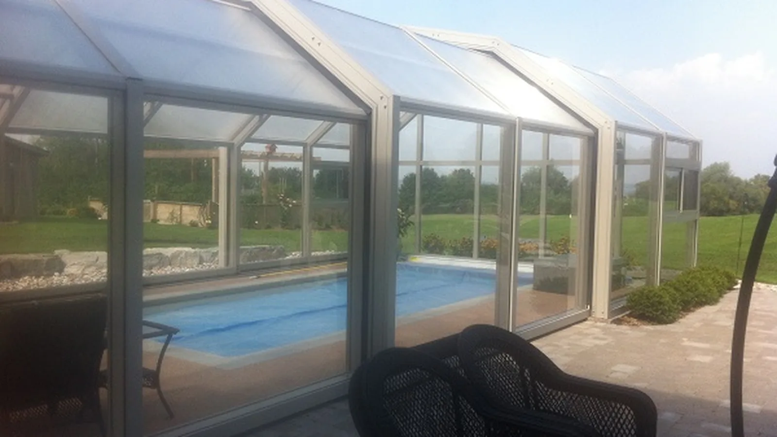 Abri de piscine haut vitré créant un espace de baignade couvert
